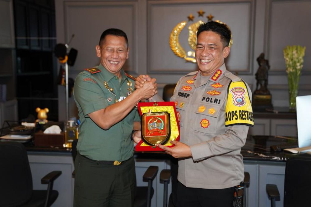 Kapolrestabes Surabaya Kombespol A. Yusep Gunawan saat memberikan cinderamata kepada Danrem 084/BJ Brigjen TNI Widjanarko