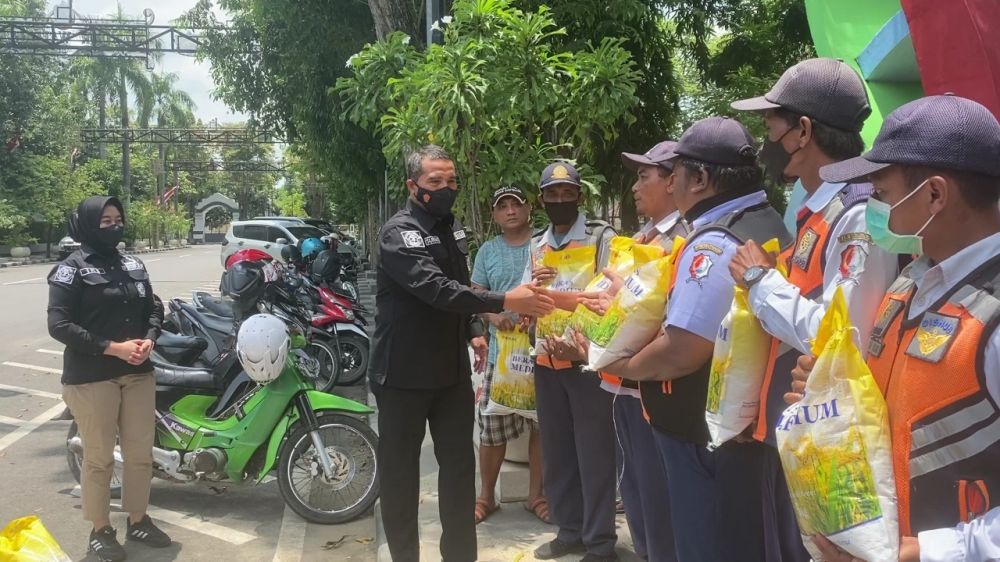Kasi Humas Ipda Supriyanto saat memberikan paket bantuan ke tukang parkir