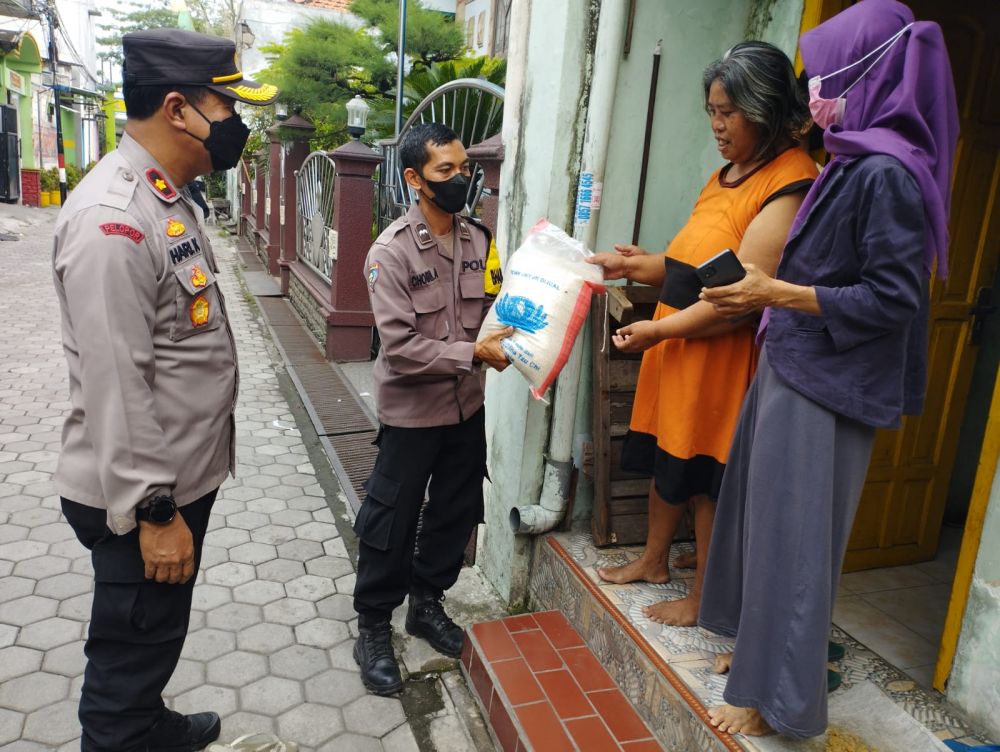 Kapolsek Asemrowo Kompol Hari Kurniawan saat membagikan bantuan dari Polda Jatim