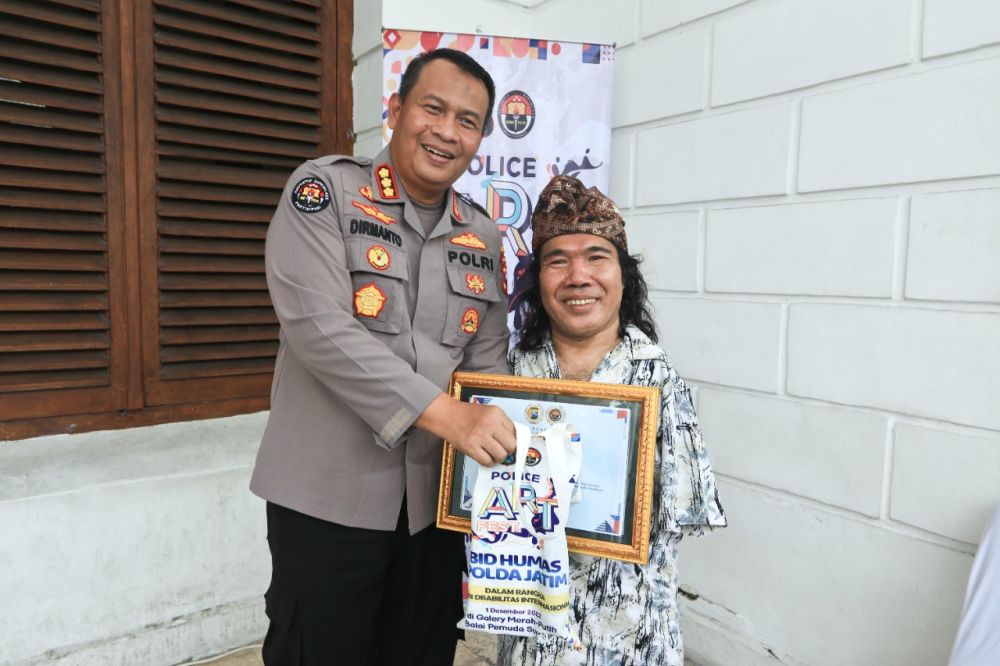 Kabid Humas Polda Jatim Kombespol Dirmanto saat bersama seniman lukis mulut dan kaki