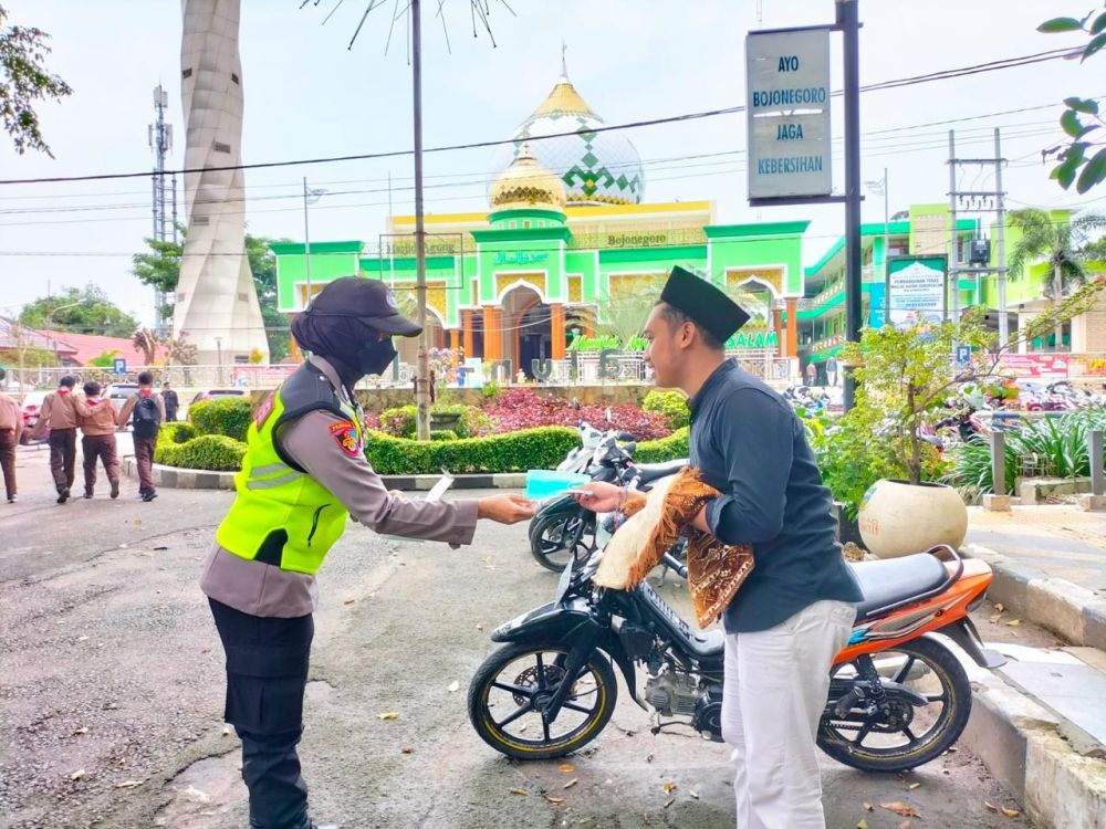 Polwan Polres Bojonegoro lakukan pengamanan dan berbagi masker saat jemaah pulang dari masjid
