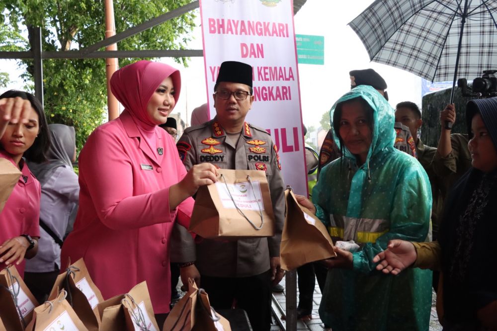 Kapolresta Banyuwangi Kombespol Deddy Foury Millewa bersama ketua Bhayangkari Reny Deddy Millewa berbagi takjil ke pengguna jalan